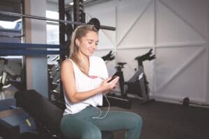 Woman sat in the gym using her phone