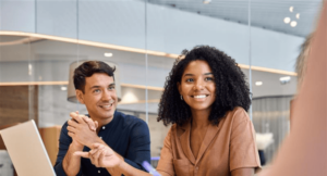 Two smiling colleagues in a meeting room