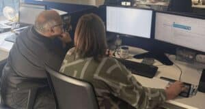 Two medicash employees facing computer screens