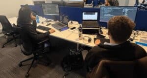 Two medicash employees facing computer screens